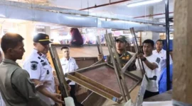 Petugas gabungan mengamankan barang-barang yang ditinggalkan pedagang di atas blok toko tidak aktif di Pasar Raya Fase VII, Rabu (28/1/2025). (Foto: Humas Satpol PP Padang)