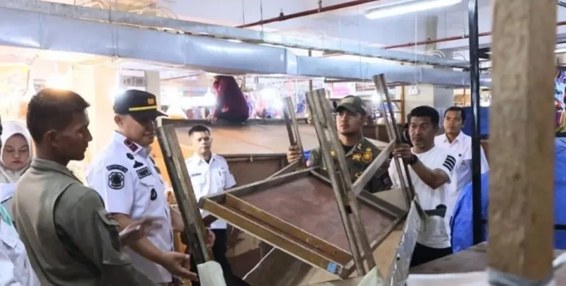 Petugas gabungan mengamankan barang-barang yang ditinggalkan pedagang di atas blok toko tidak aktif di Pasar Raya Fase VII, Rabu (28/1/2025). (Foto: Humas Satpol PP Padang)