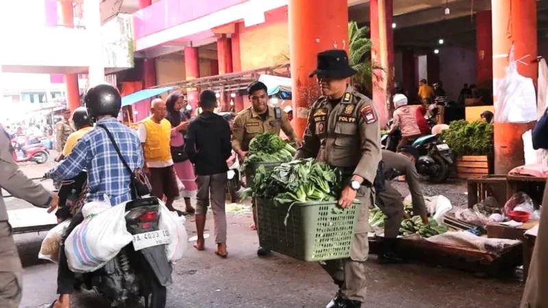 Petugas Satpol PP Padang menertibkan PKL di kawasan Pasar Raya Blok IV, Jumat (16/1/2025). (Foto: Humas Satpol PP Padang)