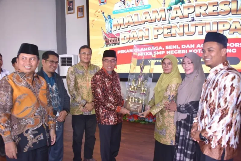 Wakil Wali Kota Padang, Maigus Nasir menyerahkan trophy juara umum PORSEMA II SMP Negeri Kota Padang kepada SMP Negeri 34 Padang. (Foto: Prokopim Padang)