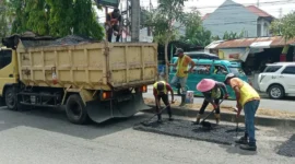 Petugas Dinas PUPR Padang melakukan patching jalan berlubang Padang di ruas Jalan Moh Hatta. (Foto: Diskominfo Padang)