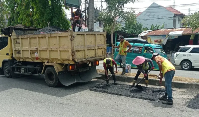 Petugas Dinas PUPR Padang melakukan patching jalan berlubang Padang di ruas Jalan Moh Hatta. (Foto: Diskominfo Padang)
