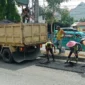 Petugas Dinas PUPR Padang melakukan patching jalan berlubang Padang di ruas Jalan Moh Hatta. (Foto: Diskominfo Padang)