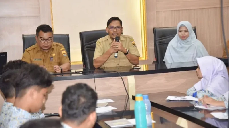 Sekretaris Dinas Kominfo Kota Pariaman, Elfadri menyambut kunjungan siswa NIBIIS Pariaman di Ruang Rapat Bappeda Kota Pariaman, Selasa (13/1/2026). (Foto: Kominfo Kota Pariaman)