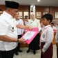 Wali Kota Bukittinggi, Ramlan Nurmatias menyerahkan reward kepada siswa berprestasi, Rabu (21/1/2026). (Foto: Kominfo Bukittinggi)