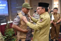 Wakil Wali Kota Padang Maigus Nasir memasangkan rompi kepada peserta Pelatihan Kelurahan Siaga Bencana di Pangeran Beach Hotel Padang, Senin (19/1/2026). (Foto: Prokopim Padang)