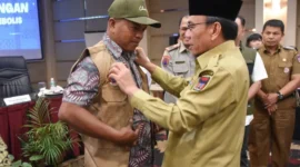 Wakil Wali Kota Padang Maigus Nasir memasangkan rompi kepada peserta Pelatihan Kelurahan Siaga Bencana di Pangeran Beach Hotel Padang, Senin (19/1/2026). (Foto: Prokopim Padang)