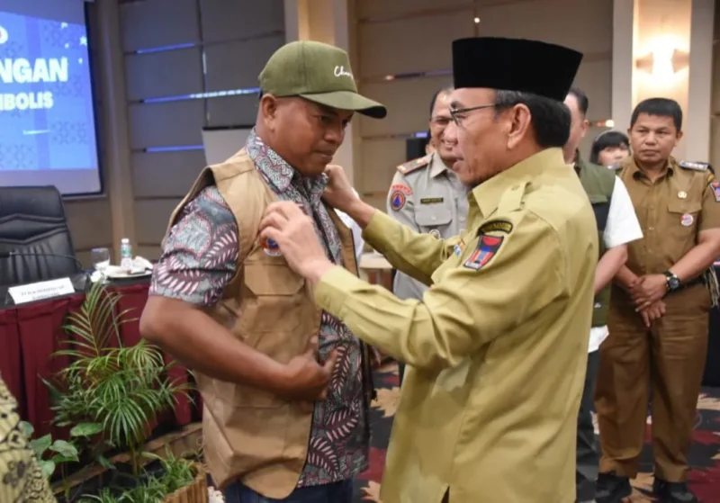 Wakil Wali Kota Padang Maigus Nasir memasangkan rompi kepada peserta Pelatihan Kelurahan Siaga Bencana di Pangeran Beach Hotel Padang, Senin (19/1/2026). (Foto: Prokopim Padang)
