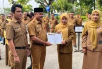 Penjabat Sekretaris Daerah Kota Padang, Raju Minropa, menyerahkan penghargaan kepada ASN berprestasi, Senin (2/2/2026). (Foto: Diskominfo Padang)