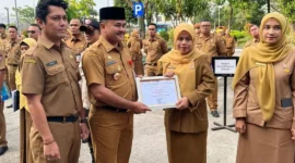 Penjabat Sekretaris Daerah Kota Padang, Raju Minropa, menyerahkan penghargaan kepada ASN berprestasi, Senin (2/2/2026). (Foto: Diskominfo Padang)