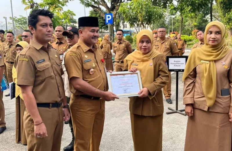 Penjabat Sekretaris Daerah Kota Padang, Raju Minropa, menyerahkan penghargaan kepada ASN berprestasi, Senin (2/2/2026). (Foto: Diskominfo Padang)