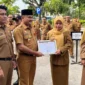 Penjabat Sekretaris Daerah Kota Padang, Raju Minropa, menyerahkan penghargaan kepada ASN berprestasi, Senin (2/2/2026). (Foto: Diskominfo Padang)