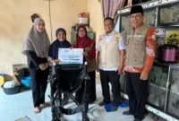 Ketua TP PKK Padang Panjang Ny. Maria Feronika Hendri bersama Baznas menyerahkan bantuan kursi roda kepada lansia, Rabu (25/2/2026). (Foto: Kominfo Padang Panjang)