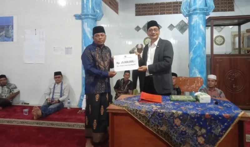
Bupati Pessel, Hendrajoni saat menyerahkan bantuan kepada ketua pengurus Madjid Ibrahim, Kampung Nyiur Gading, Asrimal Andri. (Foto: Dok. Naurah)