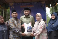 Wali Kota Padang Fadly Amran menyerahkan bantuan sebanyak 50 ton beras dari Dani Faizal kepada masyarakat Kota Padang, Sabtu (14/2/2026). (Foto: Prokopim Padang)