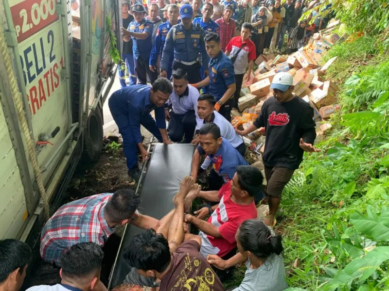 Petugas Damkar Padang mengevakuasi warga yang tertimpa mobil box di Jalan Padang–Painan, Kelurahan Labuhan Tarok, Kecamatan Bungus Teluk Kabung, Kota Padang, Selasa pagi (3/2/2026). (Foto: Dinas Damkar Padang)