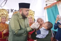 Wali Kota Padang, Fadly Amran memberikan vitamin kepada balita saat Pekan Posyandu di Posyandu Pala Indah VIII, Kelurahan Parak Laweh Pulau Air Nan XX, Kecamatan Lubuk Begalung, Sabtu (14/2/2026). (Foto: Prokopim Padang)