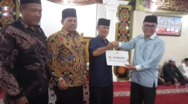 Asisten I Bidang Pemerintahan dan Kesejahteraan Rakyat, Syahrizal Antoni didampingi Ketua DPRD Pessel, Darmansyah menyerahkan bantuan kepada Ketua Pengurus Madjid Al Mukaromah, Zaitul. (Foto: Dok. Niks)