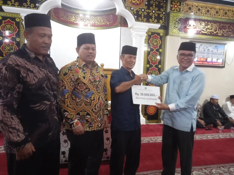 Asisten I Bidang Pemerintahan dan Kesejahteraan Rakyat, Syahrizal Antoni didampingi Ketua DPRD Pessel, Darmansyah menyerahkan bantuan kepada Ketua Pengurus Madjid Al Mukaromah, Zaitul. (Foto: Dok. Niks)