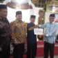 Asisten I Bidang Pemerintahan dan Kesejahteraan Rakyat, Syahrizal Antoni didampingi Ketua DPRD Pessel, Darmansyah menyerahkan bantuan kepada Ketua Pengurus Madjid Al Mukaromah, Zaitul. (Foto: Dok. Niks)