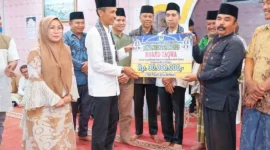Wakil Bupati Solok Selatan Yulian Efi menyerahkan bantuan saat safari Ramadan Tim II Pemerintah Kabupaten di Masjid Taqwa, Jorong Sawah Siluak, Bomas, Kecamatan Sungai Pagu, Selasa (24/2/2026) malam. (Foto: Diskominfo Solsel)