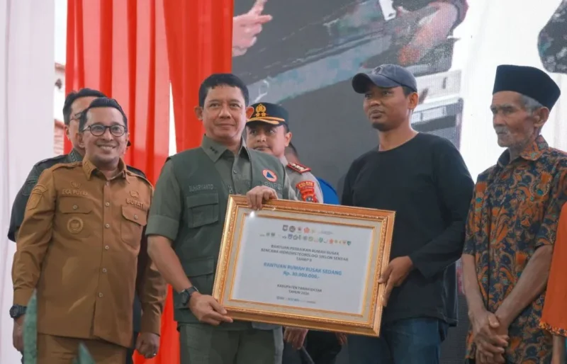 Kepala BNPB Letjen TNI Suharyanto menyerahkan dana stimulan secara simbolis kepada korban terdampak bencana hidrometeorologi di Tanah Datar, Selasa (3/3/2026). (Foto: Prokopim Tanah Datar)