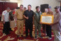 Direktur Rehabilitasi dan Rekonstruksi Infrastruktur BNPB, Afrial Rosya didampingi Ketua DPRD Pessel, Darmansyah dan Asisten I Bidang Pemerintahan dan Kesejahteraan Rakyat, Syahrizal Antoni saat menyerahkan bantuan secara simbolis kepada masyarakat. (Foto: Dok. Niks)