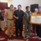 Direktur Rehabilitasi dan Rekonstruksi Infrastruktur BNPB, Afrial Rosya didampingi Ketua DPRD Pessel, Darmansyah dan Asisten I Bidang Pemerintahan dan Kesejahteraan Rakyat, Syahrizal Antoni saat menyerahkan bantuan secara simbolis kepada masyarakat. (Foto: Dok. Niks)
