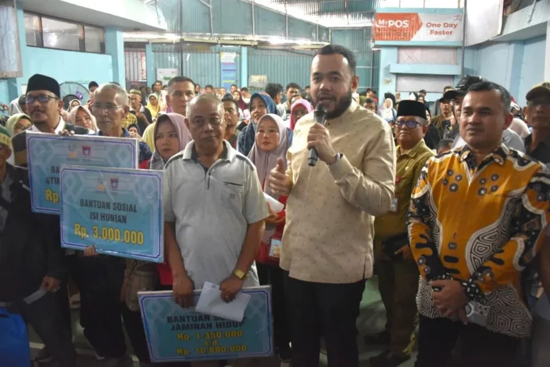 Wali Kota Padang Fadly Amran menyerahkan bantuan dari Presiden RI kepada masyarakat yang terdampak bencana hidrometeorologi di Kantor Pos Padang, Senin (16/3/2026). (Foto: Prokopim Padang)