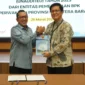 Bupati Tanah Datar Eka Putra menerima LKPD dari Kepala Bidang Pemeriksaan Sumbar II Nelson Siregar di aula Kantor BPK RI Perwakilan Sumbar, Kamis (26/3/2026). (Foto: Prokopim Tanah Datar)
