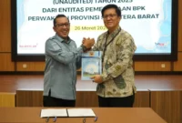 Bupati Tanah Datar, Eka Putra menyerahkan LKPD 2025 kepada Kepala Bidang Pemeriksaan Sumbar II, Nelson Siregar di aula Kantor BPK RI di Padang, Kamis (26/3/2026). (Foto: Prokopim Tanah Datar)