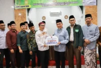 Wakil Wali Kota Padang, Maigus Nasir menyerahkan bantuan hibah dari Pemko Padang kepada pengurus Musala Amanah, Kamis (5/3/2026). (Foto: Prokopim Padang)