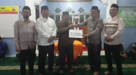 Asisten I Bupati Pessel Syahrizal Antoni menyerahkan bantuan kepada pengurus Masjid Nurul Iman saat kunjungan Safari Ramadhan di Kampung Rangeh, Nagari Kambang Barat. (Foto: Dok. Niks)