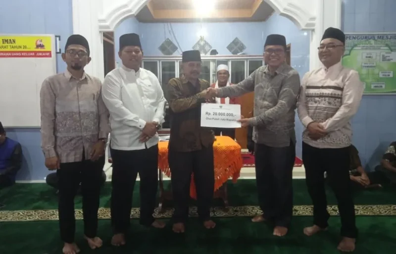 Asisten I Bupati Pessel Syahrizal Antoni menyerahkan bantuan kepada pengurus Masjid Nurul Iman saat kunjungan Safari Ramadhan di Kampung Rangeh, Nagari Kambang Barat. (Foto: Dok. Niks)
