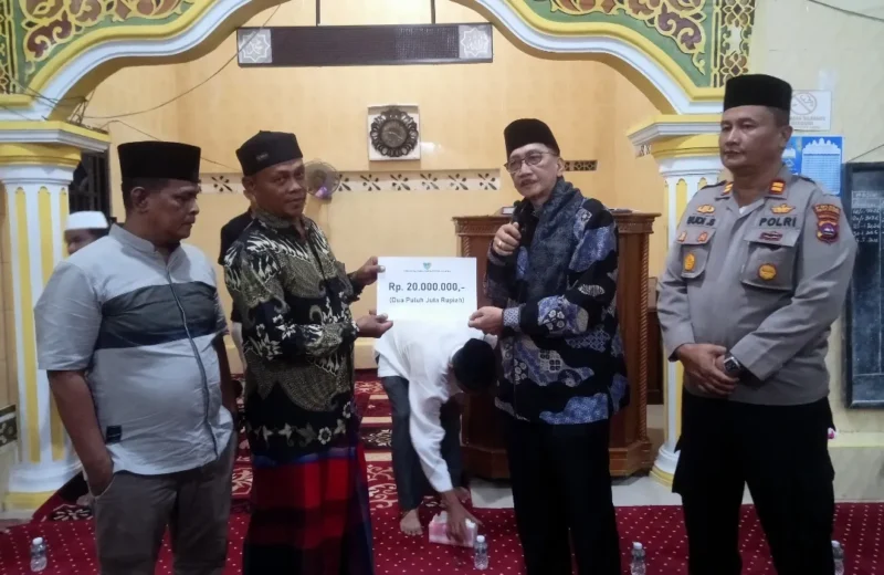 Bupati Pessel, Hendrajoni saat menyerahkan bantuan untuk pembangunan Masjid Thoiyibah, kepada ketua pengurus Masjid, Syahrial. (Foto: Dok. Niks)
