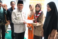 Wakil Wali Kota Padang, Maigus Nasir menyerahkan santunan kepada anak yatim dan piatu binaan Masjid Ukhuwah Balai Kota Padang, Aia Pacah, Kamis (12/3/2026). (Foto: Prokopim Padang)