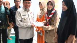 Wakil Wali Kota Padang, Maigus Nasir menyerahkan santunan kepada anak yatim dan piatu binaan Masjid Ukhuwah Balai Kota Padang, Aia Pacah, Kamis (12/3/2026). (Foto: Prokopim Padang)
