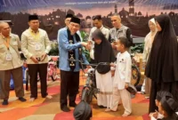 Wakil Wali Kota Padang Maigus Nasir menyerahkan hadiah secara simbolis kepada anak yatim yang hadir. (Foto: Diskominfo Padang)