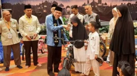 Wakil Wali Kota Padang Maigus Nasir menyerahkan hadiah secara simbolis kepada anak yatim yang hadir. (Foto: Diskominfo Padang)