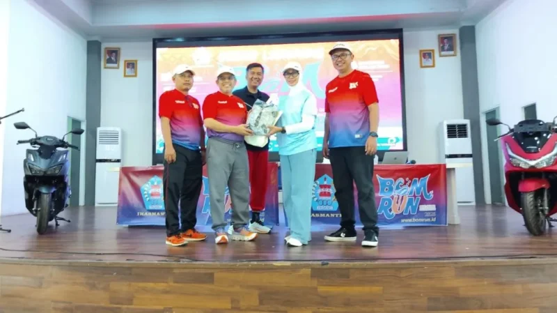 Penyerahan cenderamata dari Ketua Umum PB Ikasmantri, dr. Rahyussalim kepada Plt Kepala Dispora Padang Corri Saidan saat Grand Launching BOM RUN 2026, Minggu (12/4). (Foto: Ist)