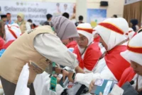Petugas mendatangi jemaah untuk membagikan gelang, paspor, nomor kamar, dan manifes penerbangan. (Foto: Humas Kemenhaj Sumbar)