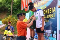 Wakil Wali Kota Payakumbuh, Elzadaswarman mengakungkan medali kepada pemenang Kejurda Akuatik Sumbar 2026 di Kolam Renang Ngalau Indah, Jumat (10/4/2026). (Foto: MC Payakumbuh)