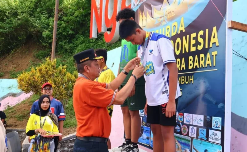 Wakil Wali Kota Payakumbuh, Elzadaswarman mengakungkan medali kepada pemenang Kejurda Akuatik Sumbar 2026 di Kolam Renang Ngalau Indah, Jumat (10/4/2026). (Foto: MC Payakumbuh)