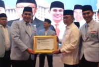 Menteri Koordinator Pangan, Zulkifli Hasan menyerahkan penghargaan kepada DPW BKPRMI Sumbar pada Rapimnas BKPRMI 2026, Kamis (14/5/26) di Jakarta. (Foto: Ist)