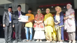 Pj. Sekda Padang Pariaman Hendra Aswara menyerahkan penghargaan bupati kepada Kadri Maiwansyah dalam upacara peringatan Hari Otonomi Daerah dan Hardiknas di halaman Kantor Bupati, Senin (4/5/2026). (Foto: Diskominfo Padang Pariaman)