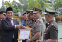 Kepala Satpol PP Kota Padang, Chandra Eka Putra menerima penghargaan Karya Bhakti di HUT Satpol PP ke-76, Satlinmas ke-64, dan Damkar) ke-107, Senin (25/6/2026). (Foto: Humas Satpol PP Padang)