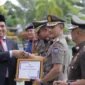 Kepala Satpol PP Kota Padang, Chandra Eka Putra menerima penghargaan Karya Bhakti di HUT Satpol PP ke-76, Satlinmas ke-64, dan Damkar) ke-107, Senin (25/6/2026). (Foto: Humas Satpol PP Padang)