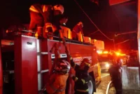 Petugas Damkar Padang Panjang berupaya memadamkan api yang menghanguskan satu unit mobil dan merusak sebagian rumah warga di kawasan Silaing Bawah, Kamis malam (28/5/2026). (Foto: Diskominfo Padang Panjang)