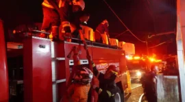Petugas Damkar Padang Panjang berupaya memadamkan api yang menghanguskan satu unit mobil dan merusak sebagian rumah warga di kawasan Silaing Bawah, Kamis malam (28/5/2026). (Foto: Diskominfo Padang Panjang)