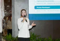 Kepala Biro Hukum dan Humas BGN, Khairul Hidayati saat menyampaikan paparan pada Rapat Koordinasi Percepatan Perolehan SLHS dan Peningkatan Kepesertaan BPJS Ketenagakerjaan di SPPG Wilayah Provinsi Sulawesi Selatan. (Foto: Biro Hukum dan Humas BGN)
